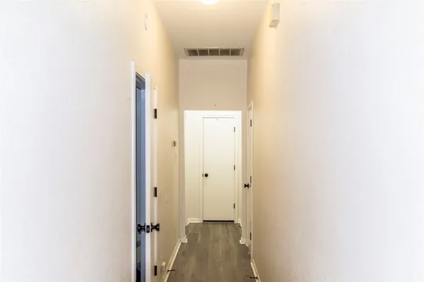a view of a hallway with wooden floor