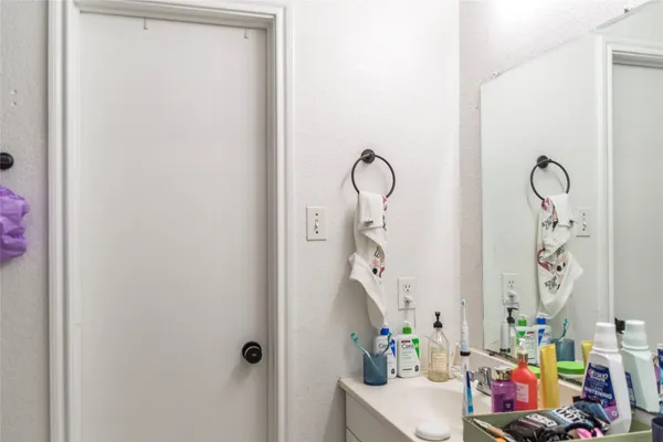 a bathroom with a sink and mirror with shower