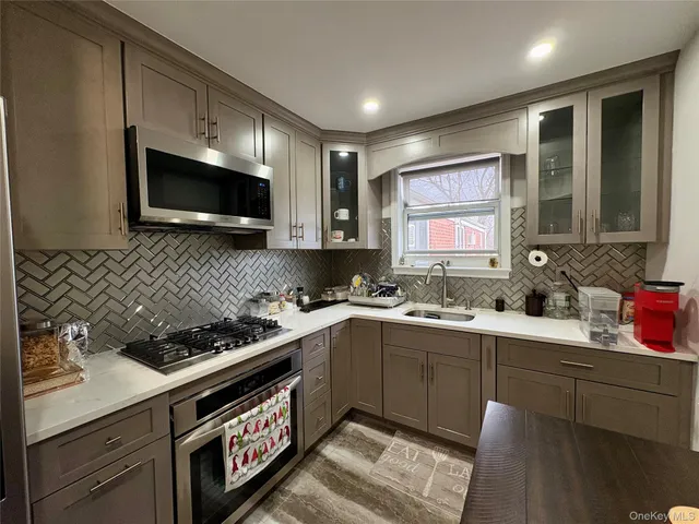 a kitchen with stainless steel appliances a stove sink microwave and cabinets