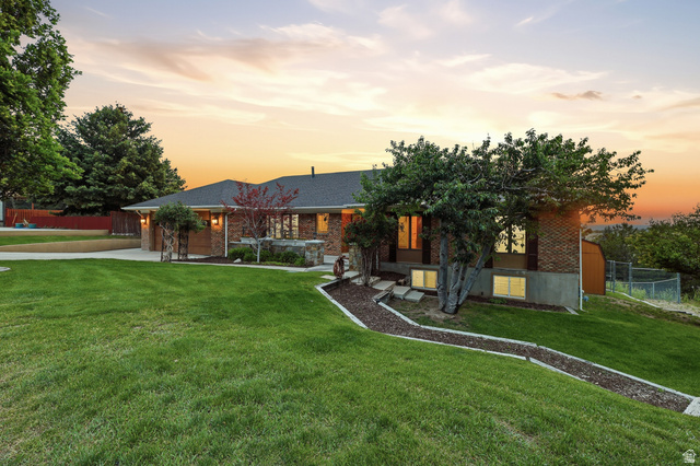 Ranch-style residence featuring a brick exterior and a dark shingle roof