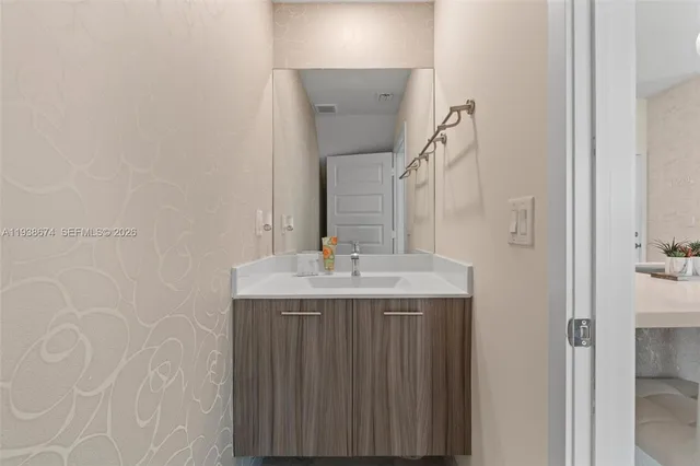 a bathroom with a granite countertop sink and a mirror
