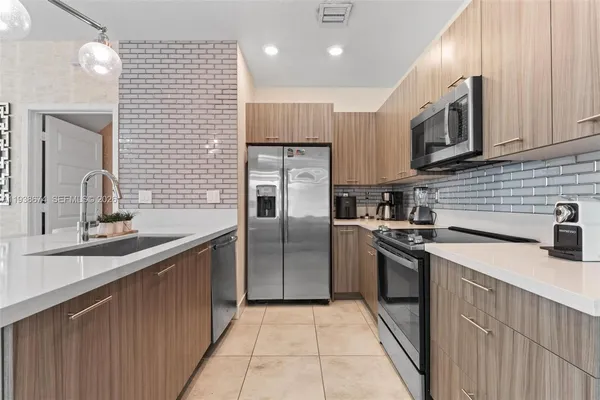 a kitchen with stainless steel appliances granite countertop a sink a stove and a refrigerator