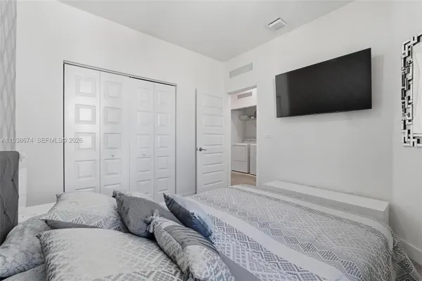 a bedroom with a bed and a flat screen tv