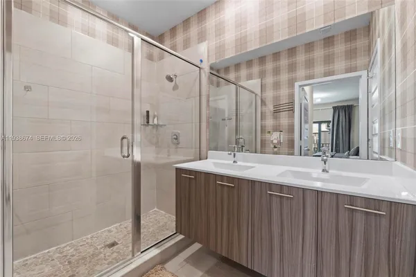 a bathroom with a double vanity sink mirror and shower