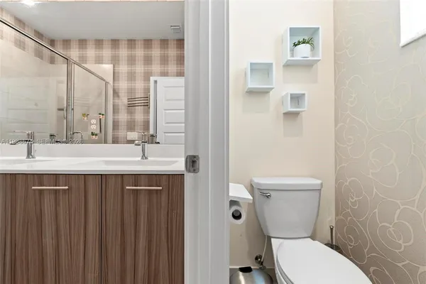 a bathroom with a sink a toilet and a mirror