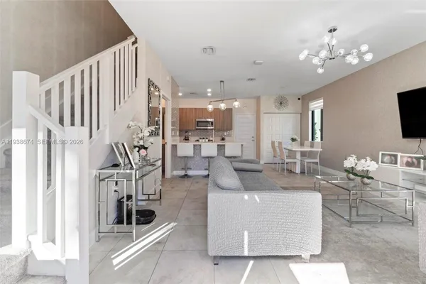 a living room with furniture and a chandelier