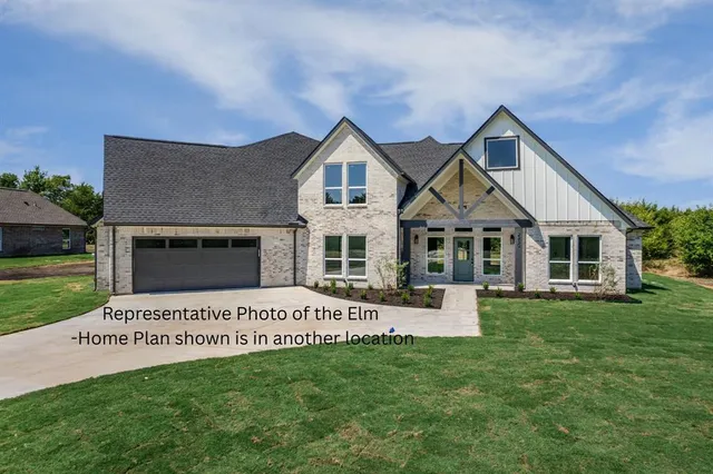 a front view of a house with a garden and yard