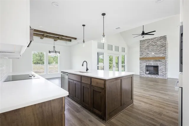 a kitchen with a sink stove and wooden floor