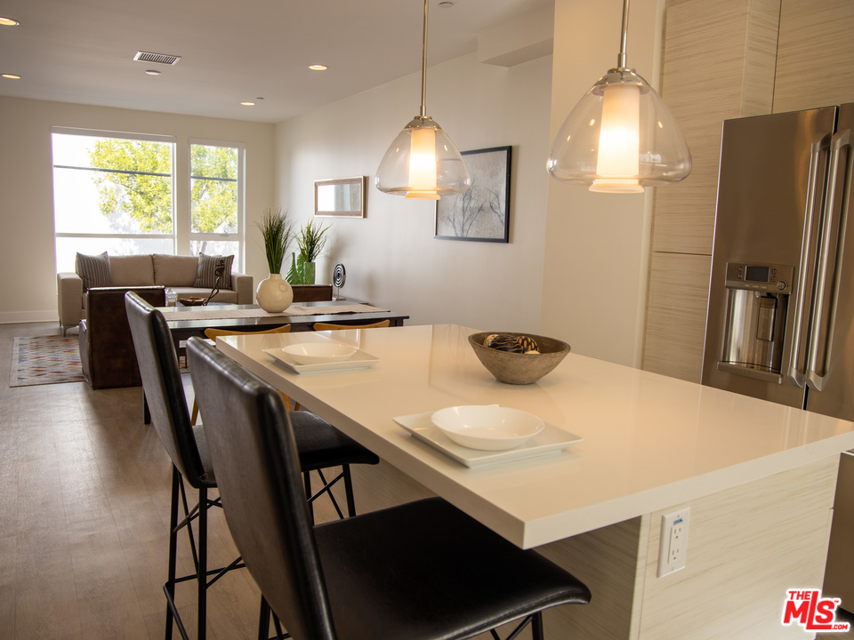 a kitchen with stainless steel appliances a table chairs and refrigerator