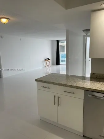 a bathroom with a granite countertop sink and white cabinets
