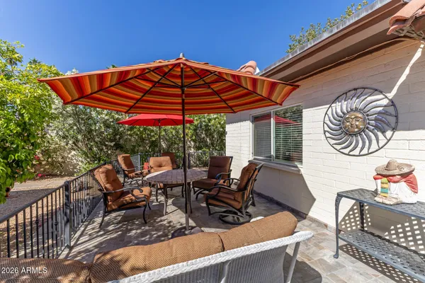 a patio with glass top table and chairs