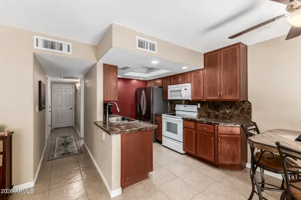 a kitchen with stainless steel appliances granite countertop a stove top oven a sink dishwasher and a refrigerator