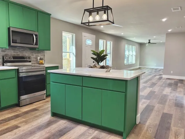 a kitchen with cabinets a microwave oven a sink and a counter top space