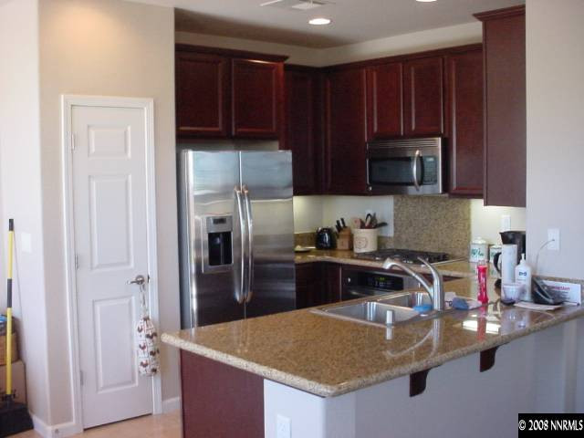 1791 A Wind Ranch Road Reno, NV 89521 - Photo 2 of 9 a kitchen with kitchen island granite countertop a sink stove and refrigerator