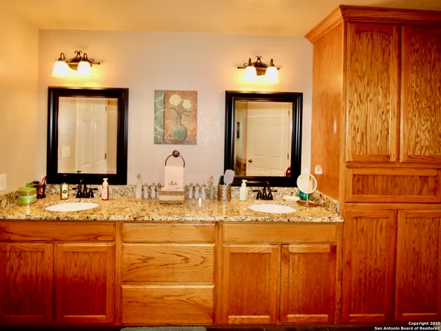 a bathroom with a granite countertop sink and a mirror