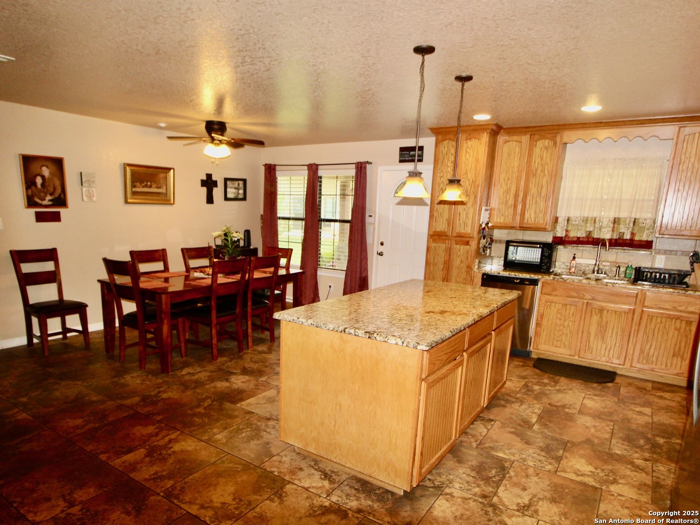 12365 Rudolph Road, Unit 3 Atascosa, TX 78002 - Photo 7 of 42 a kitchen with stainless steel appliances granite countertop a stove top oven a dining table and chairs with the view of living room