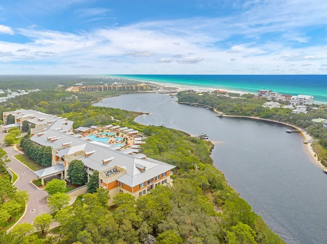 an aerial view of ocean and residential houses with outdoor space