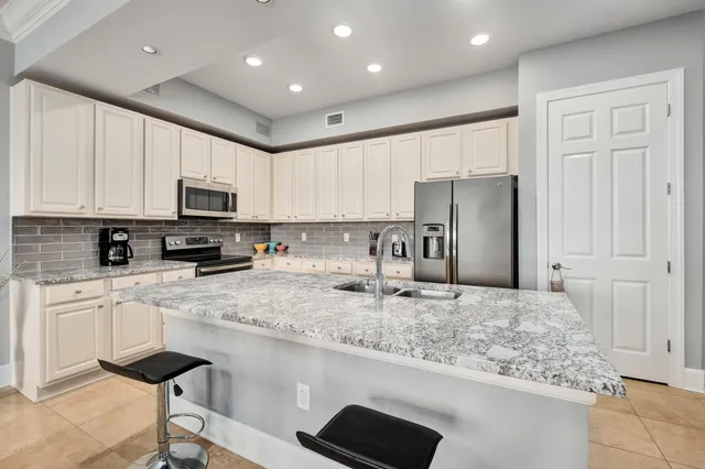 a kitchen with stainless steel appliances granite countertop a refrigerator stove microwave and sink