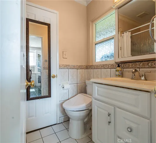 a bathroom with a toilet a sink and mirror