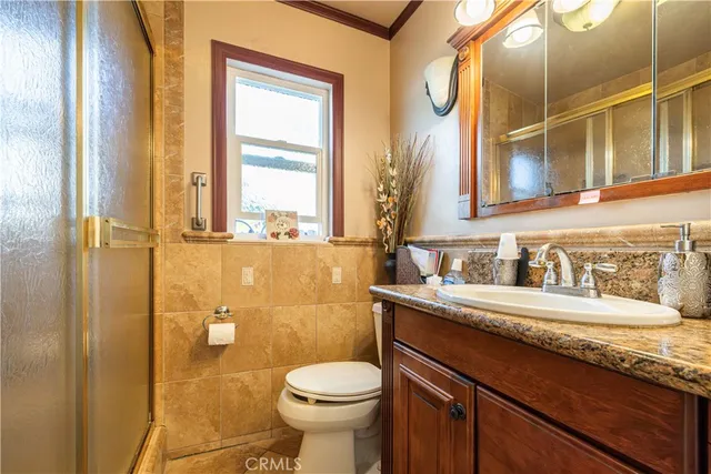 a bathroom with a granite countertop sink toilet and shower
