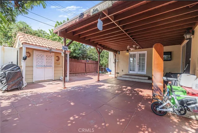 a view of backyard with wooden fence and a barbeque