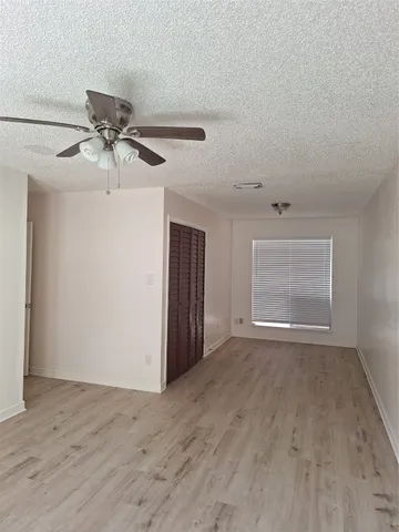 a view of room with hardwood floor and ceiling fan