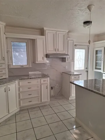 a kitchen with a stove sink and cabinets