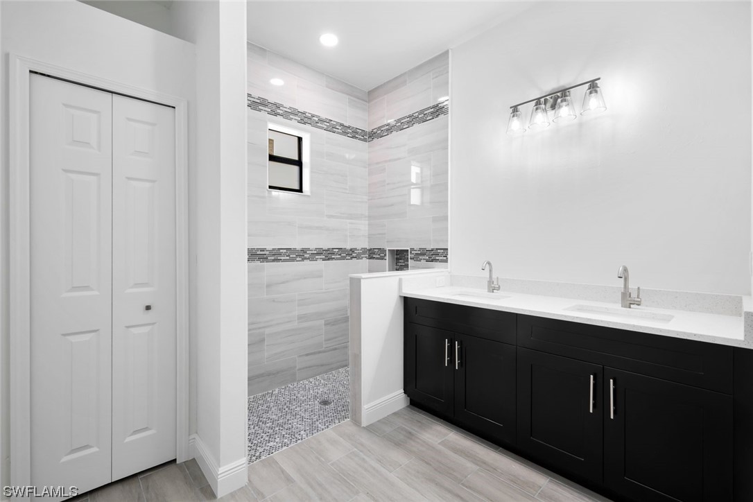 431 Progress Avenue Lehigh Acres, FL 33974 - Photo 8 of 13 a bathroom with a double vanity sink and mirror