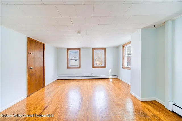 a view of a room with wooden floor and window
