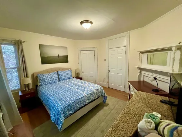 a bedroom with a bed couch and a flat screen tv