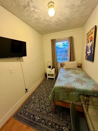 a bedroom with a bed and flat screen tv