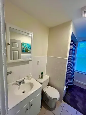 a bathroom with a toilet sink and mirror