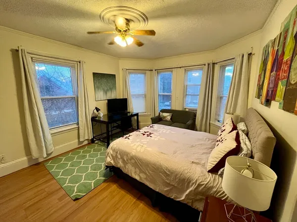 a bedroom with a bed and wooden floor