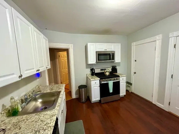 a kitchen with stainless steel appliances granite countertop a stove a sink and a microwave