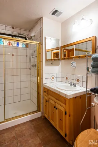 a bathroom with a sink mirror and shower