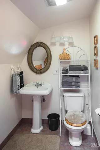 a bathroom with a toilet a sink and a mirror