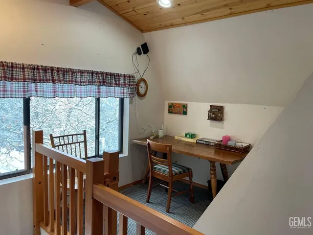 a view of a workspace with furniture and a window