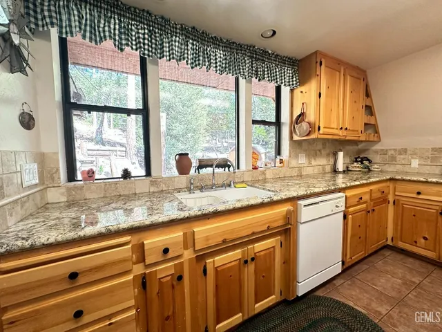 a kitchen with granite countertop a sink and a window