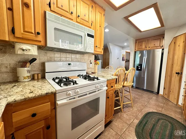 a kitchen with stainless steel appliances granite countertop a stove a refrigerator and a cabinets