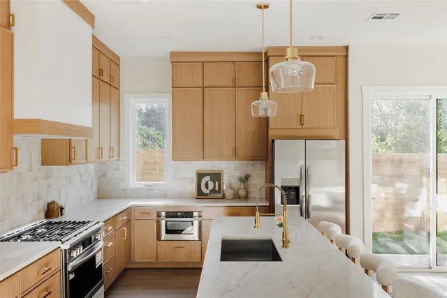 a kitchen with stainless steel appliances granite countertop a stove a sink and a refrigerator