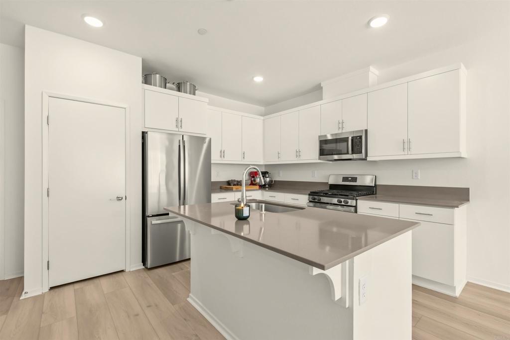 355 Citrine Trail Fallbrook, CA 92028 - Photo 12 of 27 a kitchen with a refrigerator a stove top oven a sink and cabinets