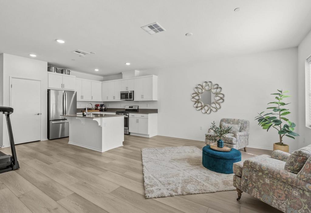 355 Citrine Trail Fallbrook, CA 92028 - Photo 4 of 27 a kitchen with stainless steel appliances kitchen island granite countertop a refrigerator a stove and a sink