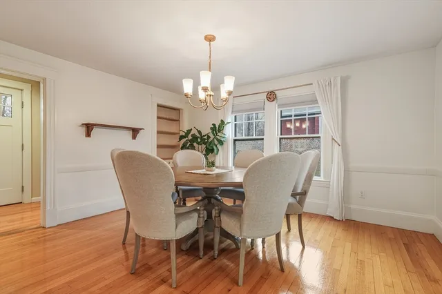a dining room with furniture a chandelier and wooden floor