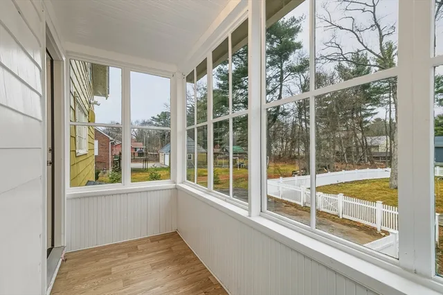 a view of a room with a large window and wooden floor