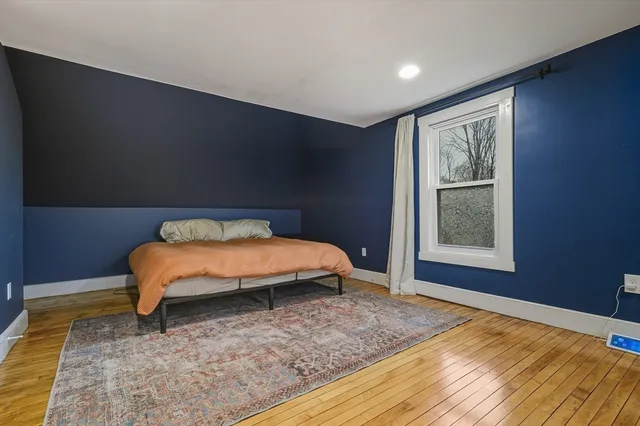 a bed sitting in a bedroom next to a window