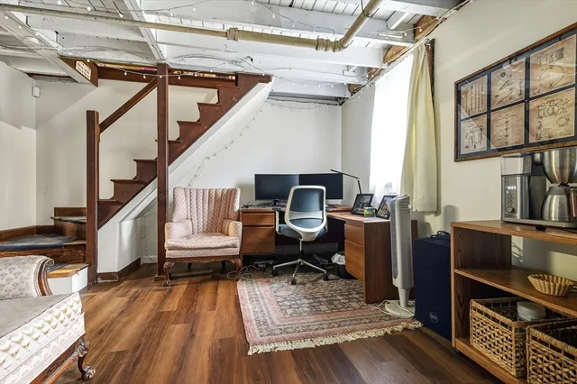 a living room with furniture floor to ceiling window and wooden floor