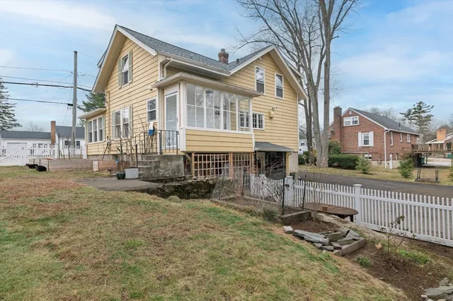 a view of a house with a small yard and wooden fence