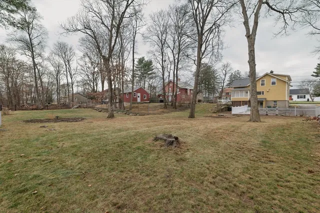 a backyard of a house with large trees and outdoor seating