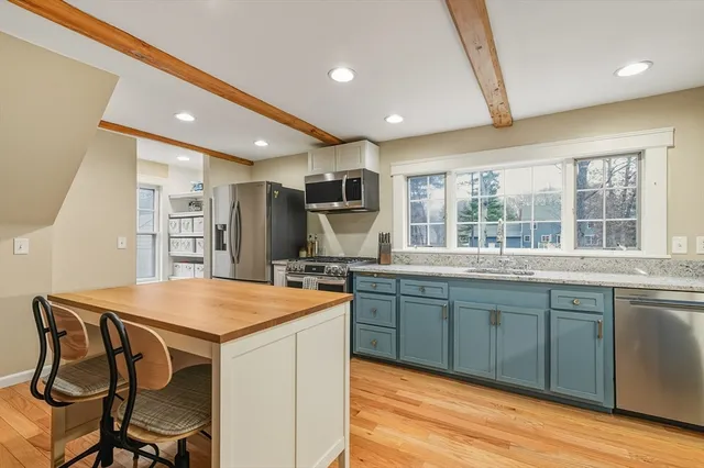 a kitchen with stainless steel appliances granite countertop wooden floor window and cabinets