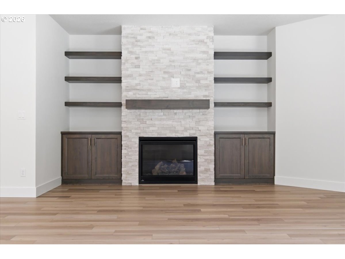 2147 Northeast Spitz Road Canby, OR 97013 - Photo 16 of 48 a view of an empty room with wooden floor and a fireplace